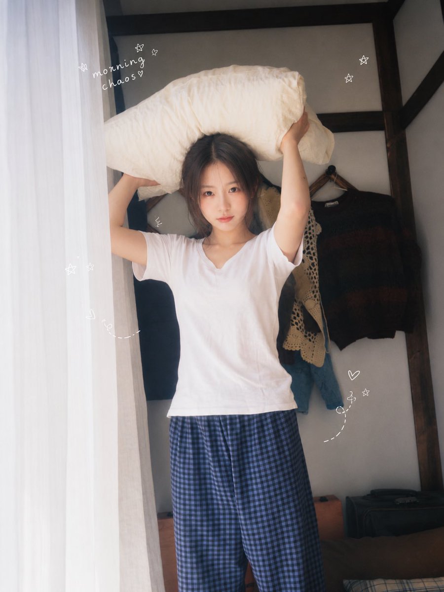 一位二十多岁的年轻东亚女性,黑色长发随意扎成低马尾,几缕碎发自然垂落,淡妆,真实自然的皮肤纹理,眼神清澈,表情慵懒又俏皮。她穿着宽松白色短袖T恤和蓝黑色格纹居家长裤,在温馨复古的小卧室里度过悠闲周末。 室内有蓝白格纹床品、木质家具、复古衣架、布艺沙发、旧报纸、早餐餐桌、面包和玻璃杯。人物做自然生活化动作:抱着枕头、趴在床上托腮、躺在沙发上发呆、举着中间挖成爱心形状的吐司、伏在桌前写字、倒躺在床上遮住半张脸。每张图片使用不同动作、视线和微表情,不要重复僵硬姿势。 窗边柔和自然晨光,白色纱帘透光,低饱和奶油色与蓝色调,清新日系居家写真,韩系生活杂志感,真实随拍构图,轻微俯拍与广角透视,浅景深,柔和高光,细腻胶片颗粒,轻微朦胧感,旧数码相机与35mm胶片质感,温暖、安静、松弛、治愈。 画面边缘加入少量白色手绘涂鸦:星星、爱心、虚线箭头、小花 and 不规则英文手写字,例如“lazy day”“slow sunday”“morning chaos”“home…